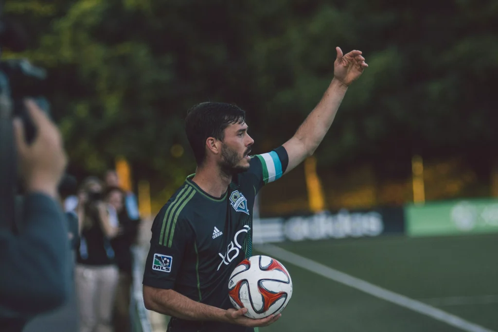 Joueur de football portant un maillot OM pas cher pendant un match de soccer dynamique.